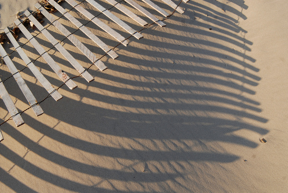 A broken snow fence casts a series of shadows along Silver Beach in St. Joseph, Mich.