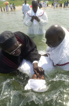 Don Campbell / H-P staff
Pastor Minus Thompson, left and Elder Curtis Ollis, right, both with the Old Path Church of God in Benton Harbor, plunge Shadara Hunter into the waters of Lake Michigan during