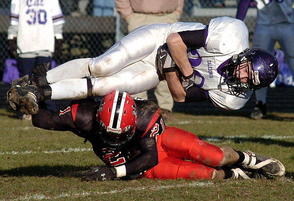 Don Campbell / H-P staff
Lakeshore's Mike Crocker (21) upends Caledonia's Steven VanderVeen (38) during the fourth quarter Saturday, November 11, 2006, at Lakeshore High School.