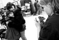 Ten-year-old Kara Fullriede, right, keeps a tight hold on one of the class guinea pigs while Shaun Dalie, 8, gets a hug goodbye from his mom, as class prepares to start, Wednesday morning at Wood Scho