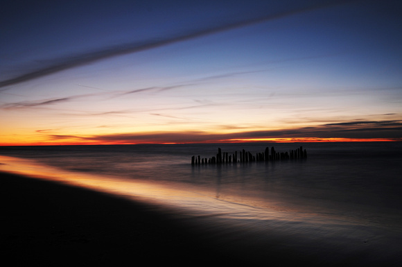 The sun sets on pilings along Lions Park Beach in St. Joseph Wednesday, November 31, 2011.