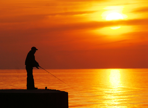 Don Campbell / H-P staff
A fisherman works the waters off the North Pier as the sun sets earlier this week.